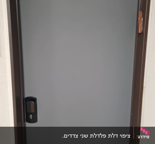 דלת אפורה עם ידית שחורה במסגרת חומה